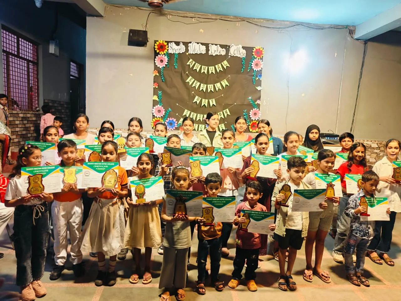 Students receiving certificates in front of a decorated display board