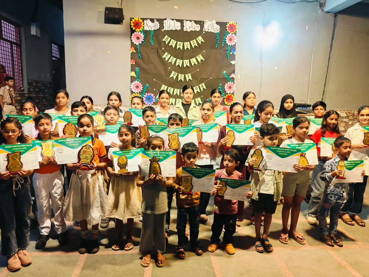 Students of Shanti Niketan Inter College holding trophies and certificates at the prize distribution
