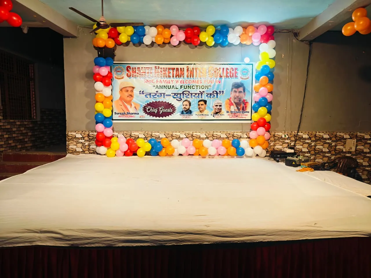 The decorated stage and annual function banner in the Shanti Niketan Inter College hall