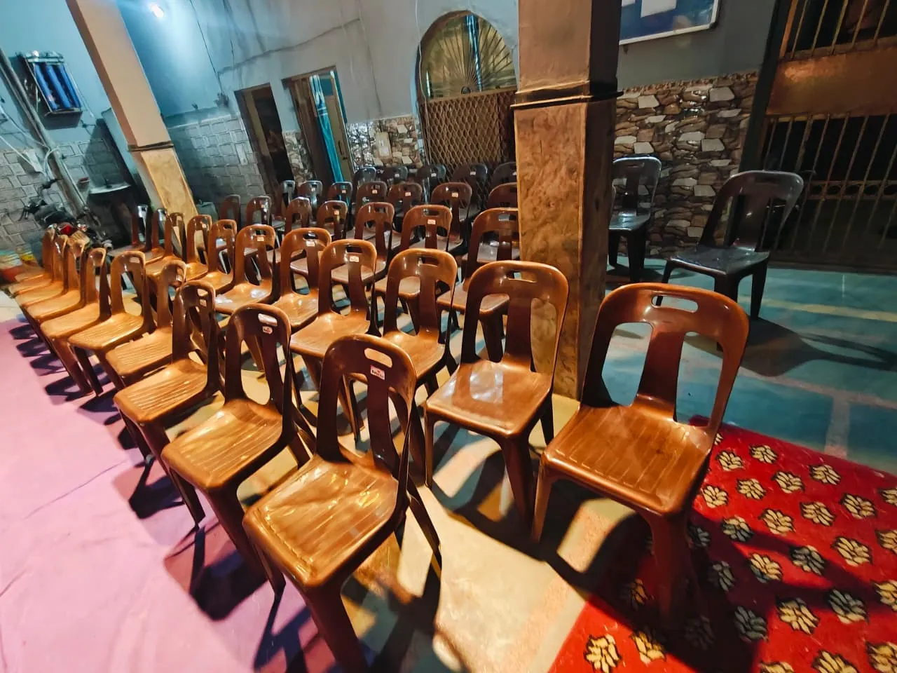 Rows of chairs set out on the carpeted floor of the school hall